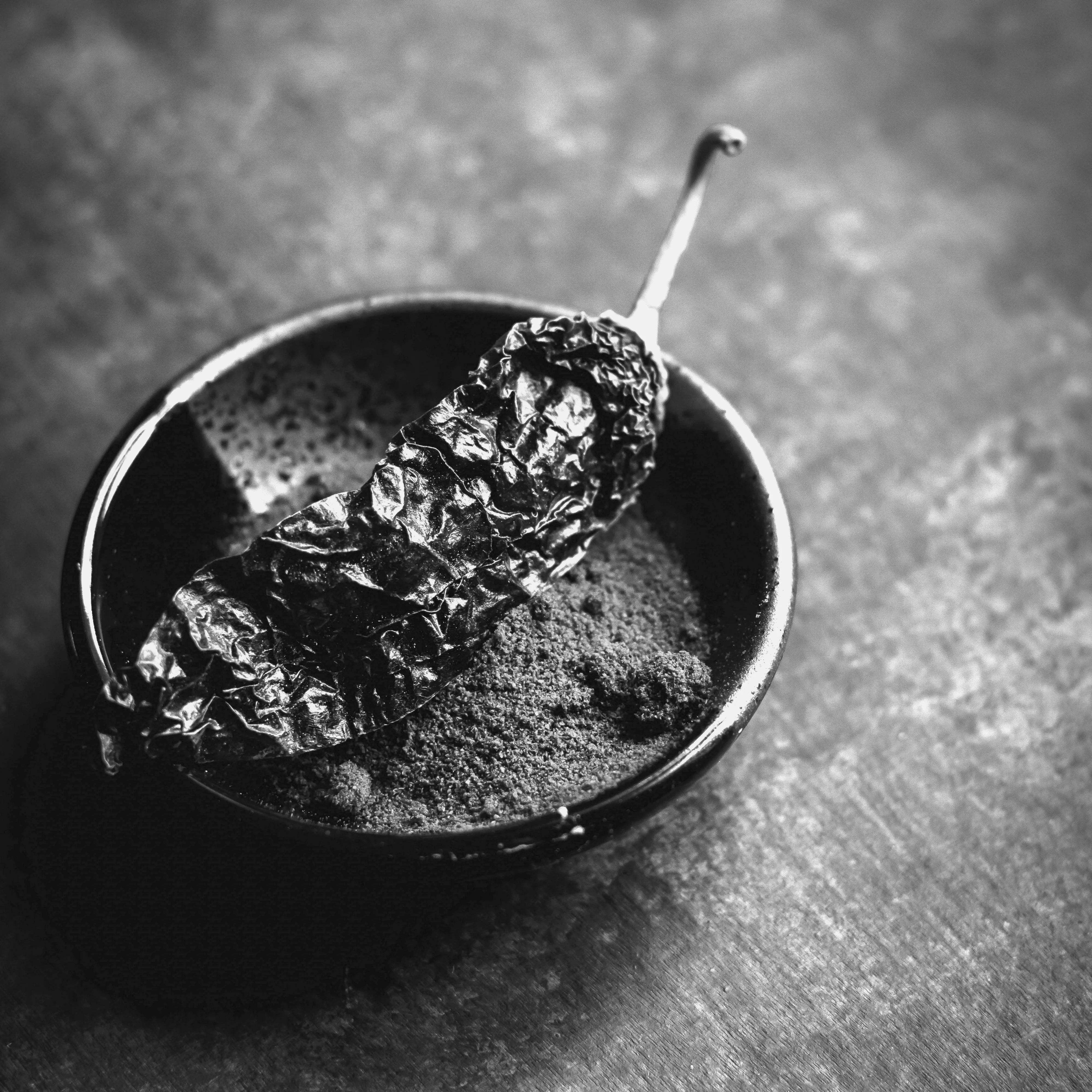 Paprika pepper in a small bowl on a dark surface