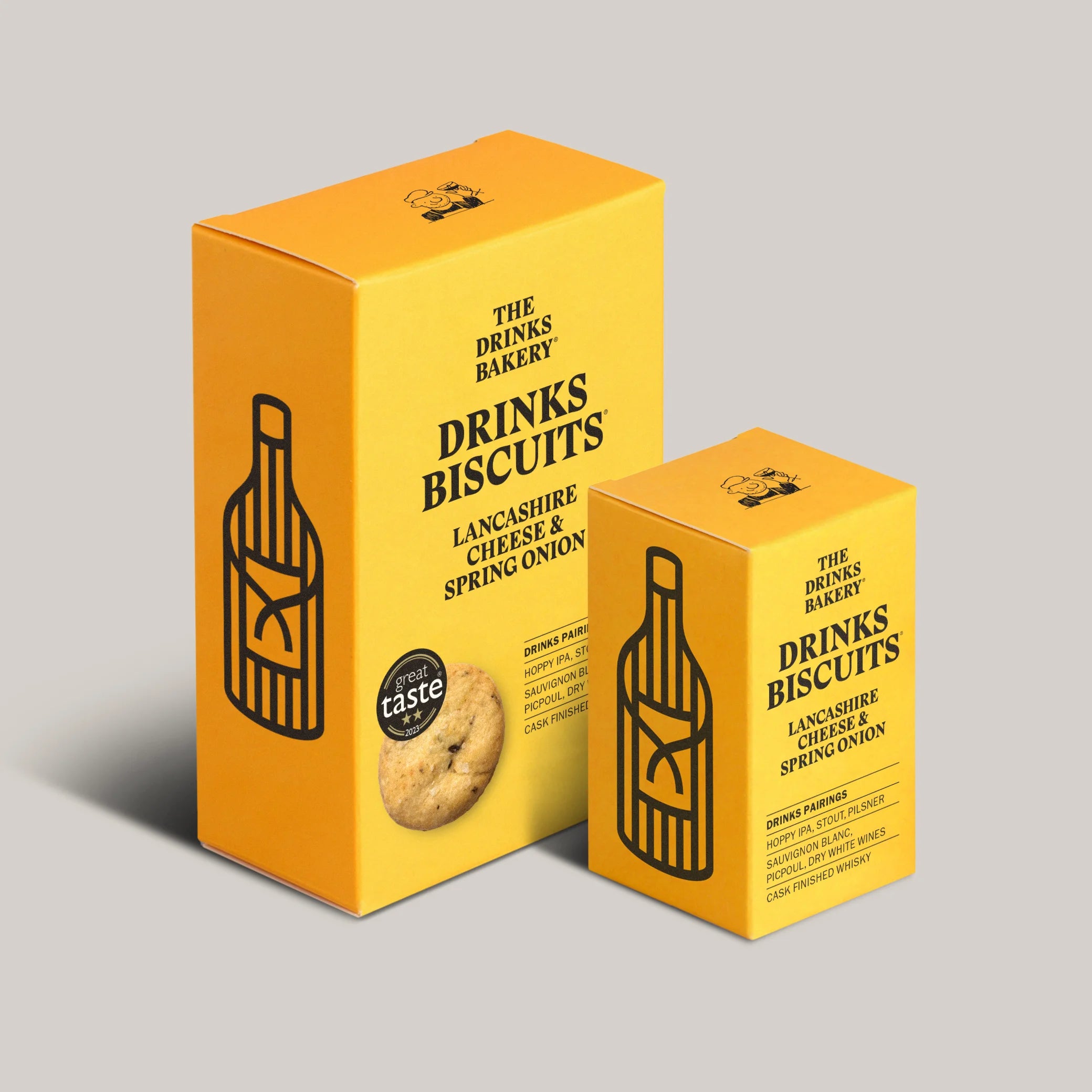 Two boxes of 'The Drinks Bakery' Lancashire Cheese & Spring Onion biscuits on a light gray background.
