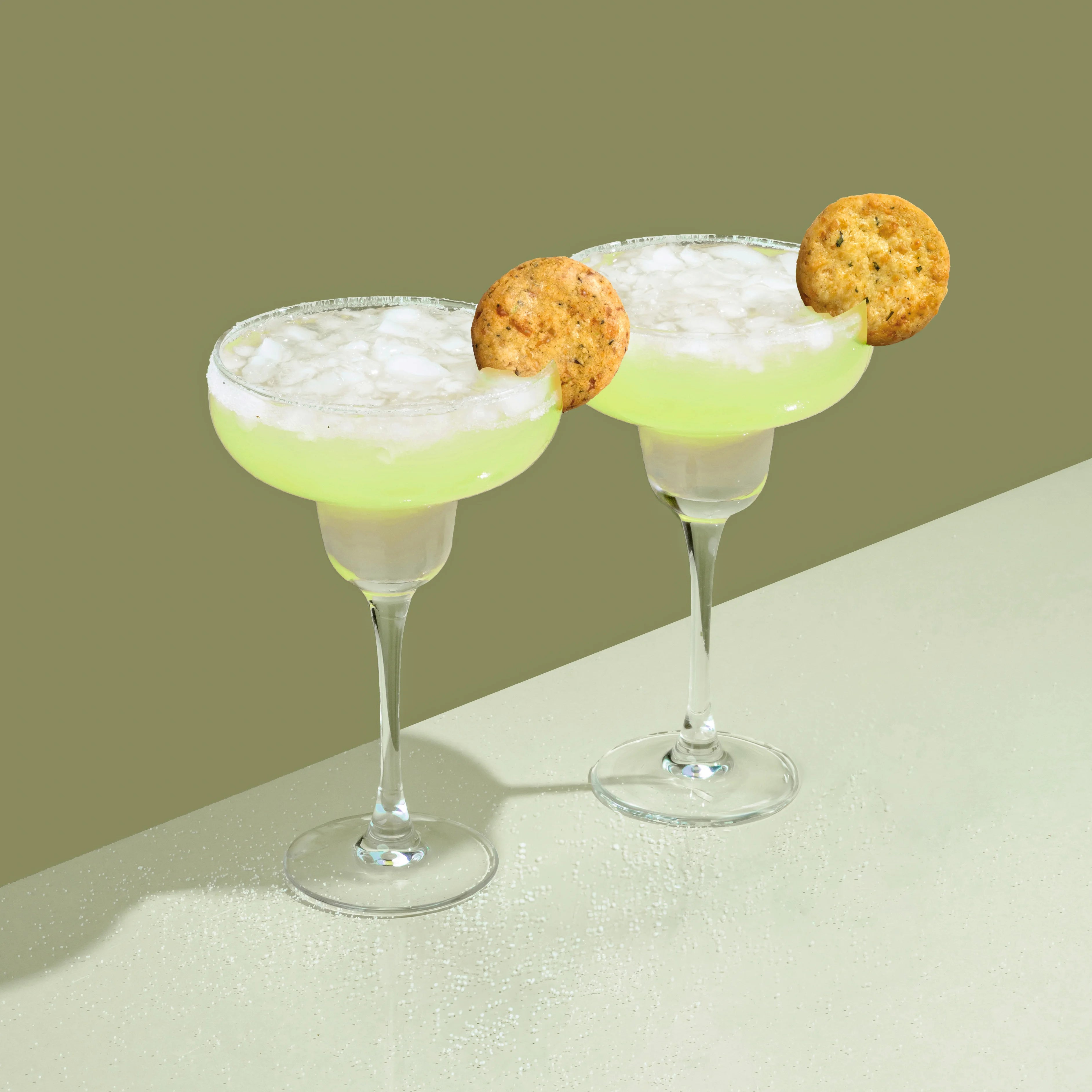 Two cocktail glasses with Drinks Biscuits in them
